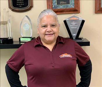 Photo of employee in front of a wall of awards