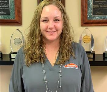 A SERVPRO employee taking a picture in front of awards to update the employee photos