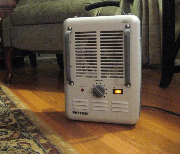 grey space heater on a wood floor