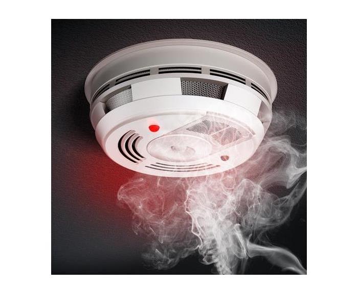 smoke alarm with smoke going up to it